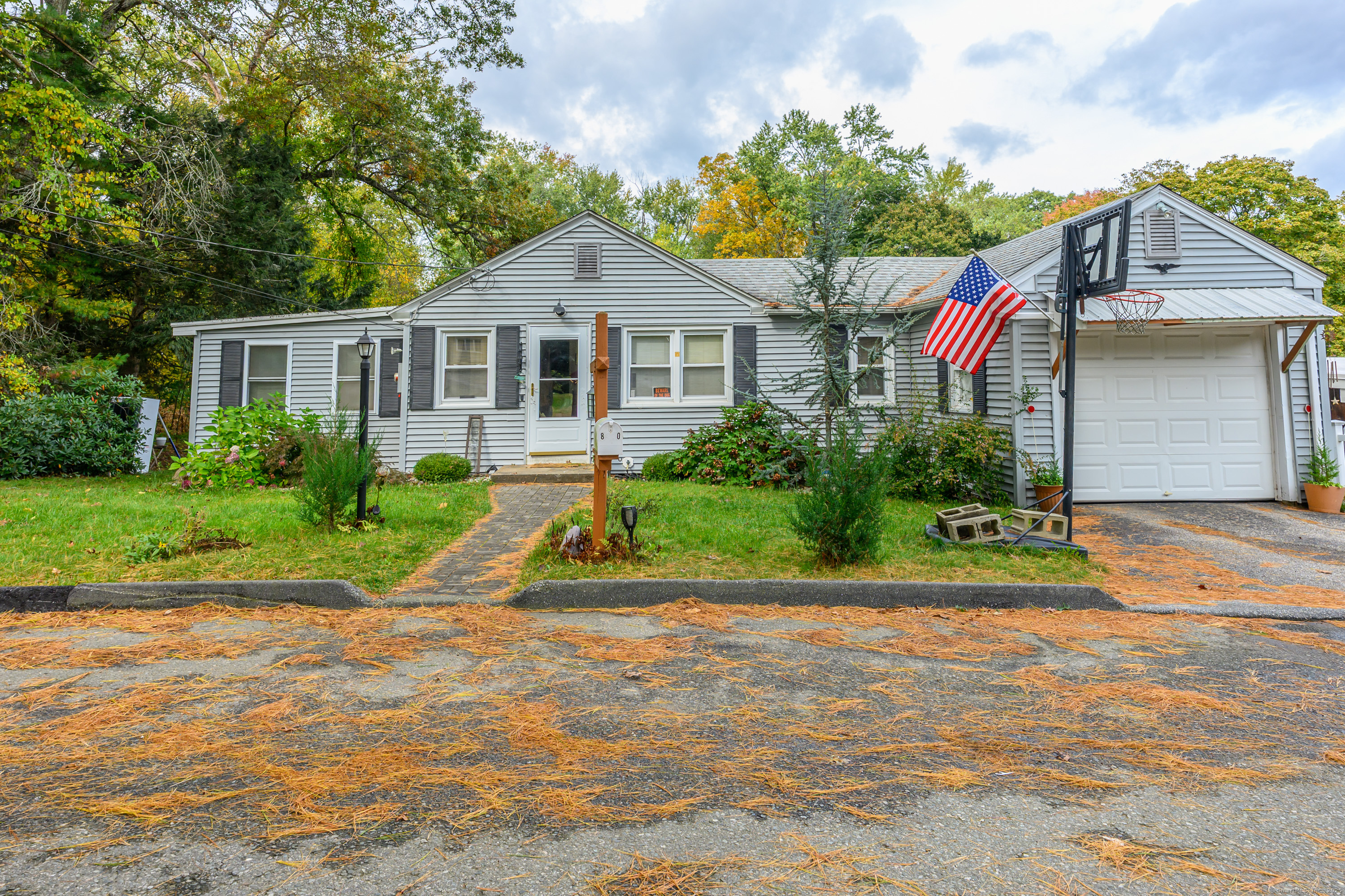 a front view of a house with a yard and potted plants