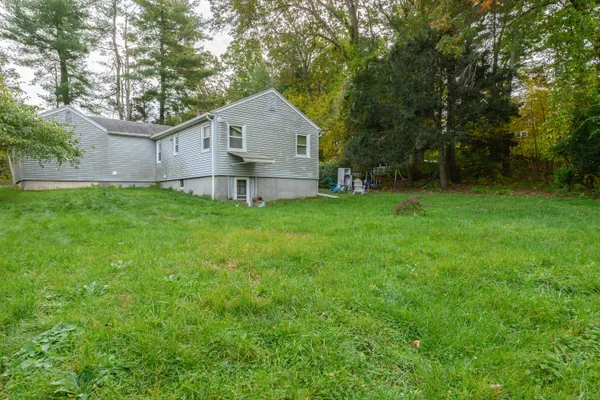 a front view of a house with a yard and trees