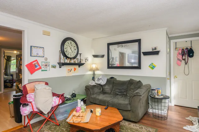 a living room with furniture and a wooden floor