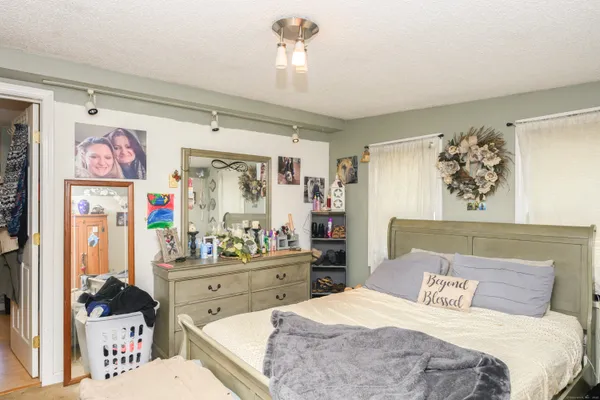 a bedroom with a bed a couch and dresser