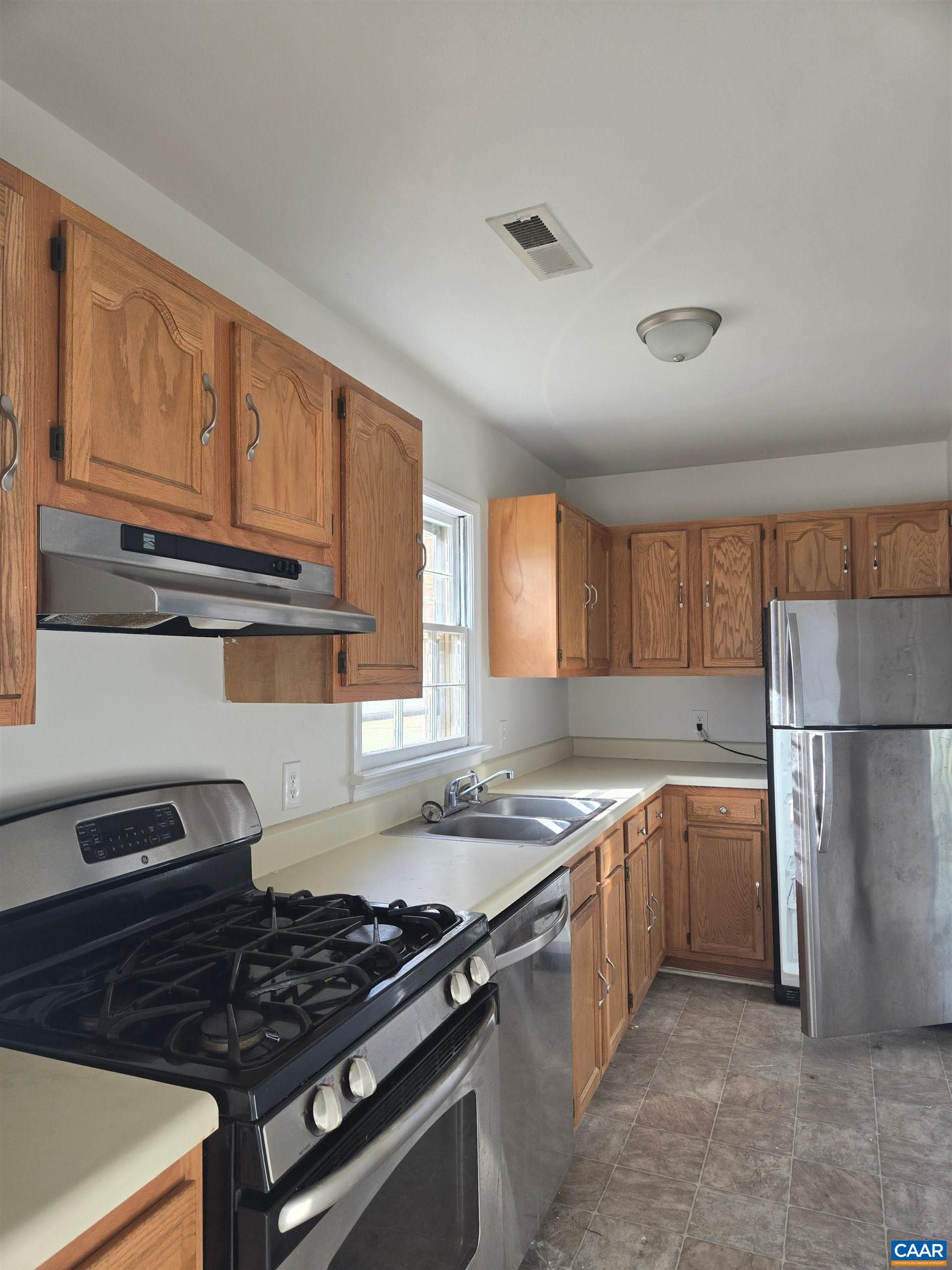 a kitchen with granite countertop a stove sink and cabinets
