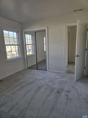 an empty room with windows and closet