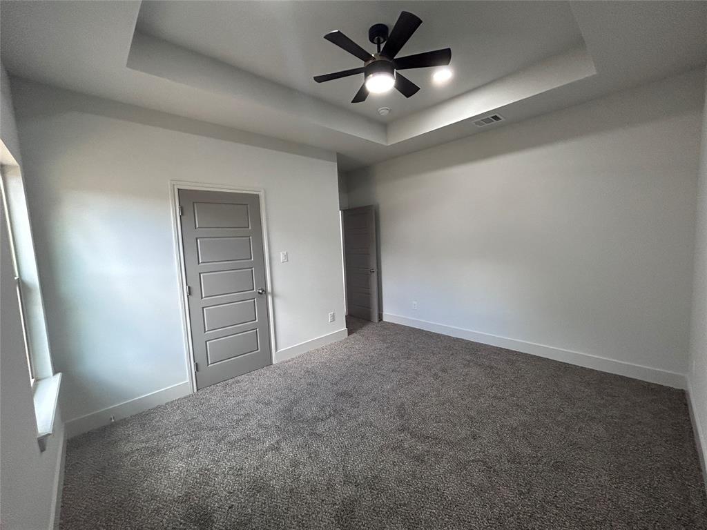 2110 Ridgewood Drive Bridgeport, TX 76426 - Photo 17 of 34 Bedroom with a raised ceiling, carpet, and ceiling fan