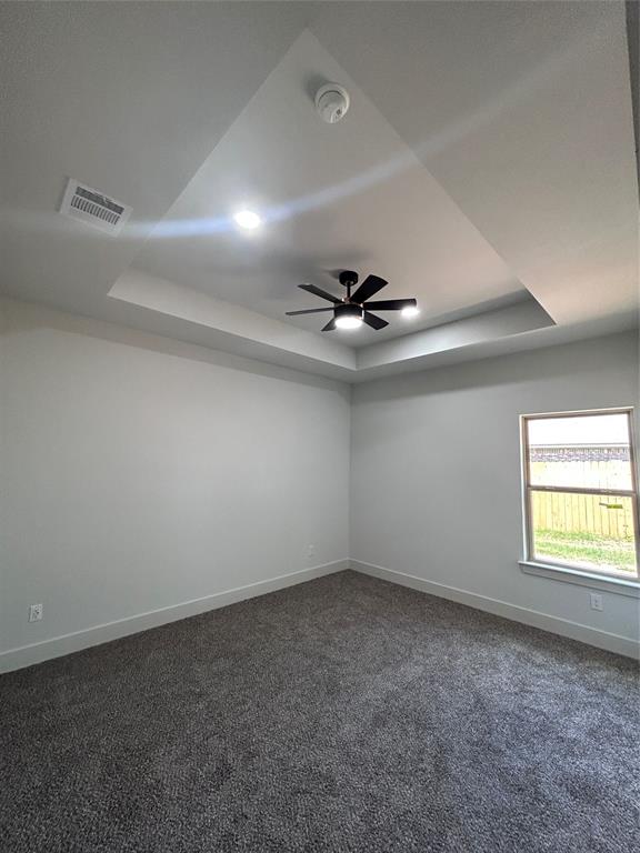 2110 Ridgewood Drive Bridgeport, TX 76426 - Photo 18 of 34 Bedroom with a raised ceiling, dark carpet, a ceiling fan, and a smoke detector