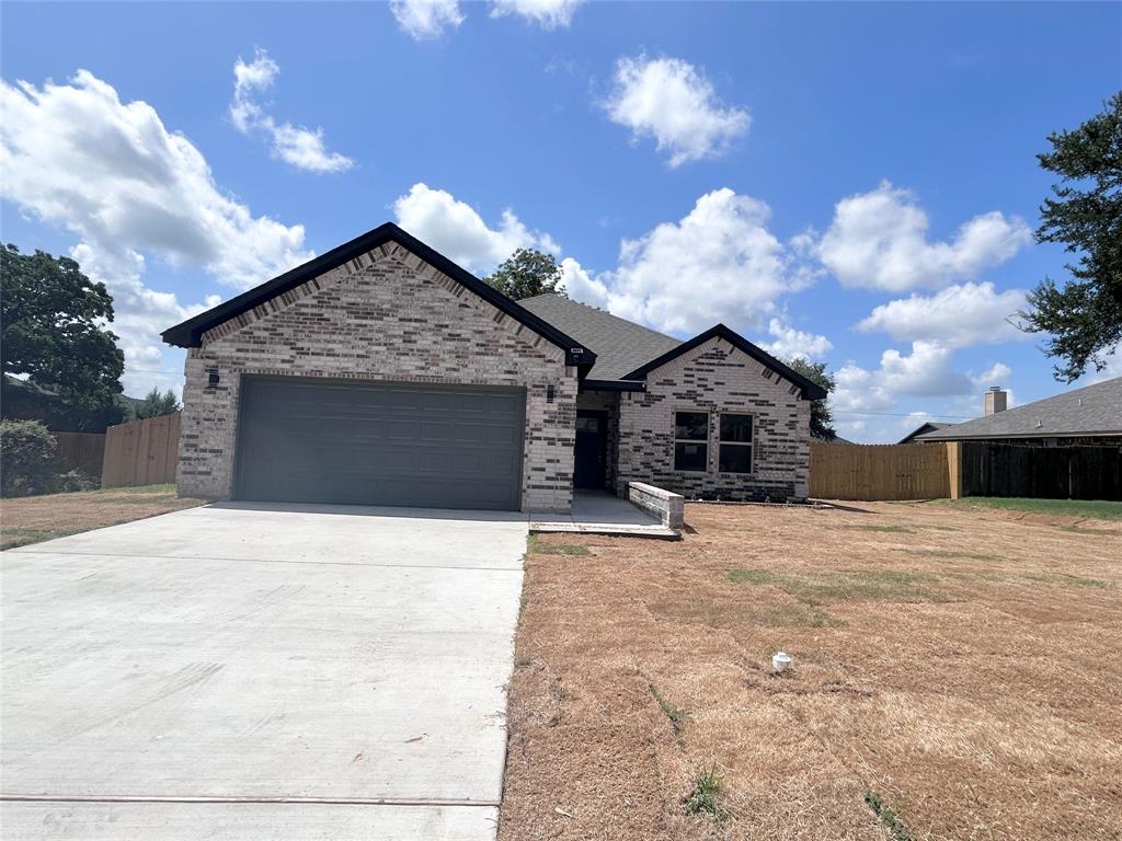 2110 Ridgewood Drive Bridgeport, TX 76426 - Photo 32 of 34 View of front of home featuring an attached garage, brick siding, and driveway