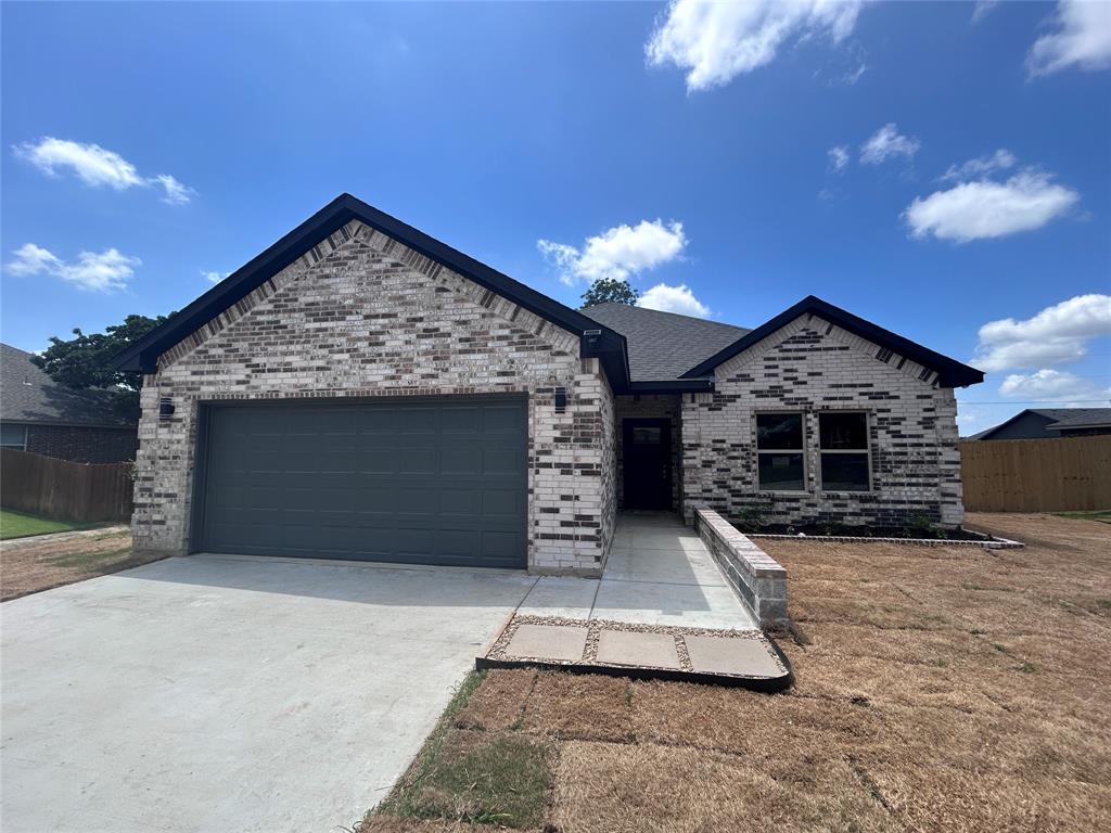 2110 Ridgewood Drive Bridgeport, TX 76426 - Photo 33 of 34 View of front of house featuring an attached garage, driveway, and brick siding