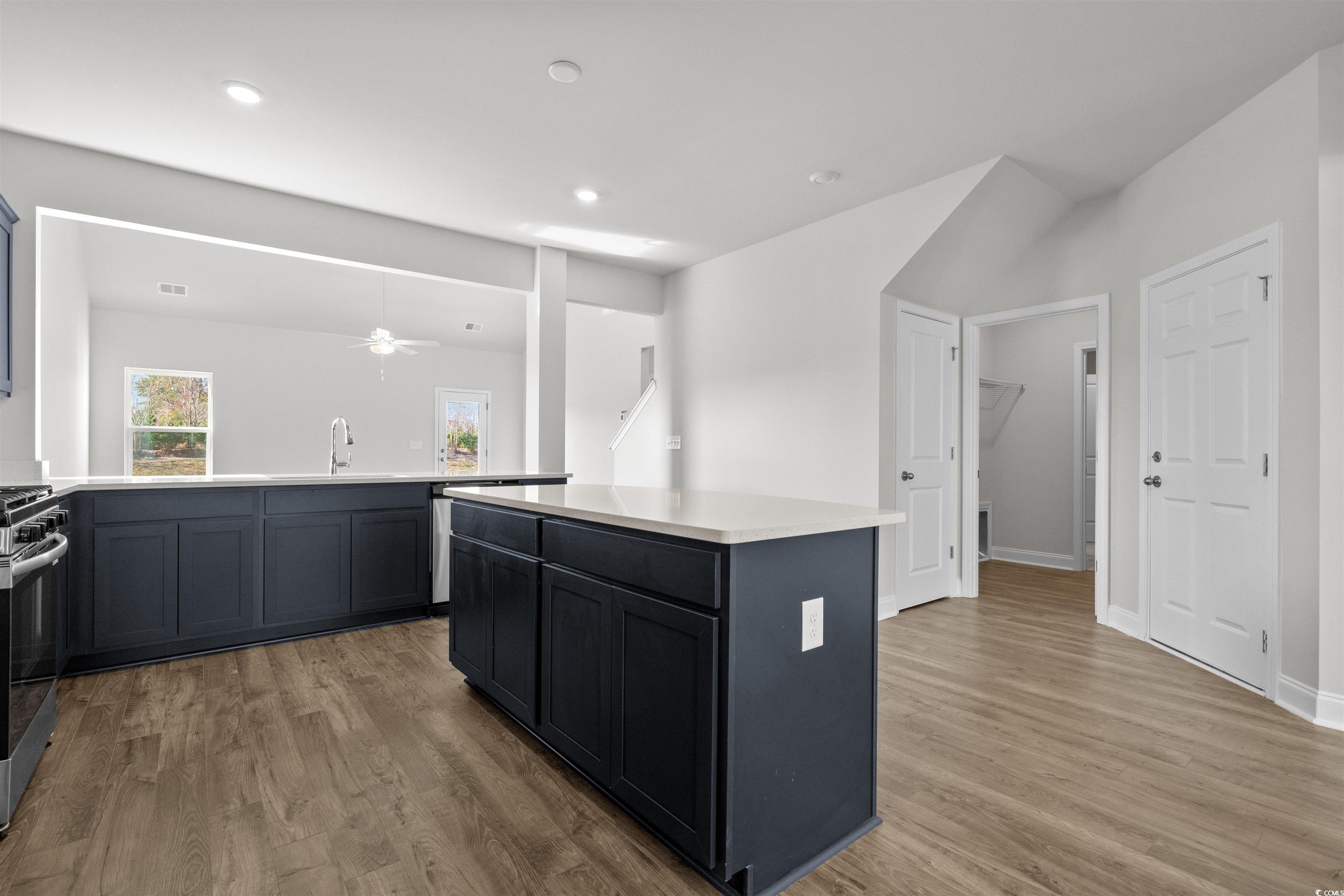 3013 Spain Lane Conway, SC 29527 - Photo 20 of 40 Kitchen with a center island, light wood-type flooring, stainless steel range with gas cooktop, ceiling fan, and a peninsula