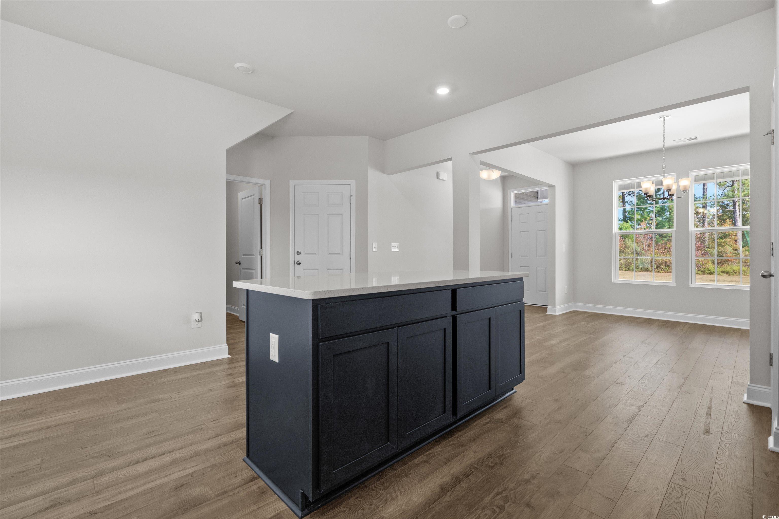3013 Spain Lane Conway, SC 29527 - Photo 21 of 40 Kitchen featuring a chandelier, dark wood-style flooring, hanging light fixtures, and a center island