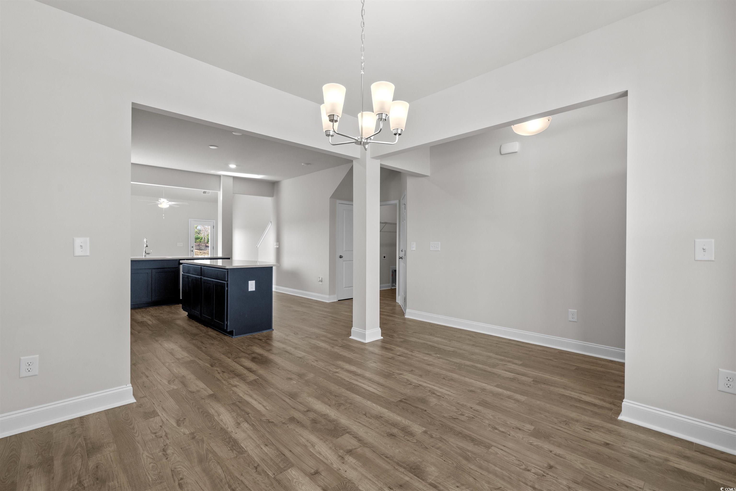 3013 Spain Lane Conway, SC 29527 - Photo 7 of 40 Unfurnished dining area featuring dark wood-type flooring, a chandelier, and a ceiling fan