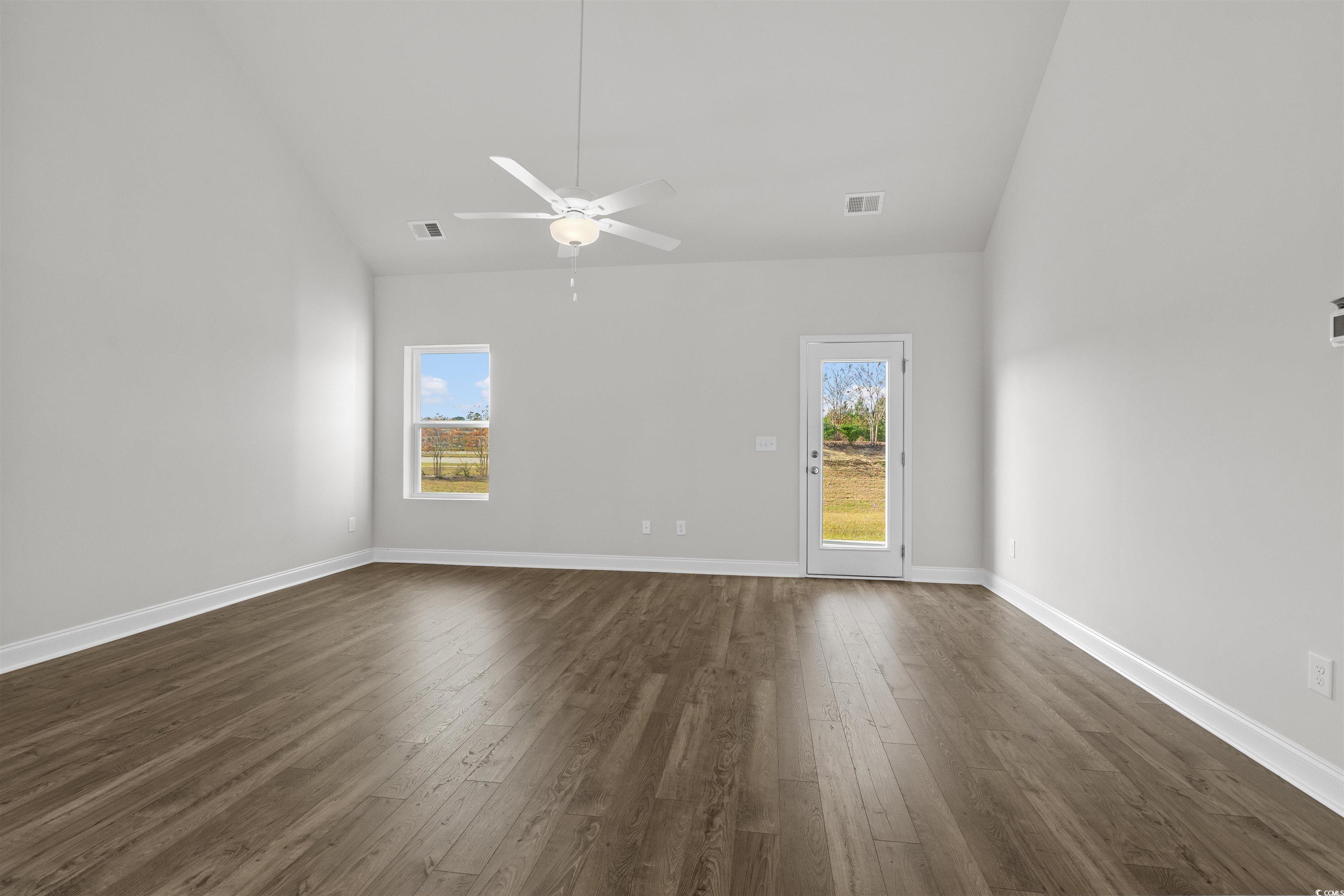 3013 Spain Lane Conway, SC 29527 - Photo 9 of 40 Empty room with dark wood finished floors, high vaulted ceiling, plenty of natural light, and ceiling fan