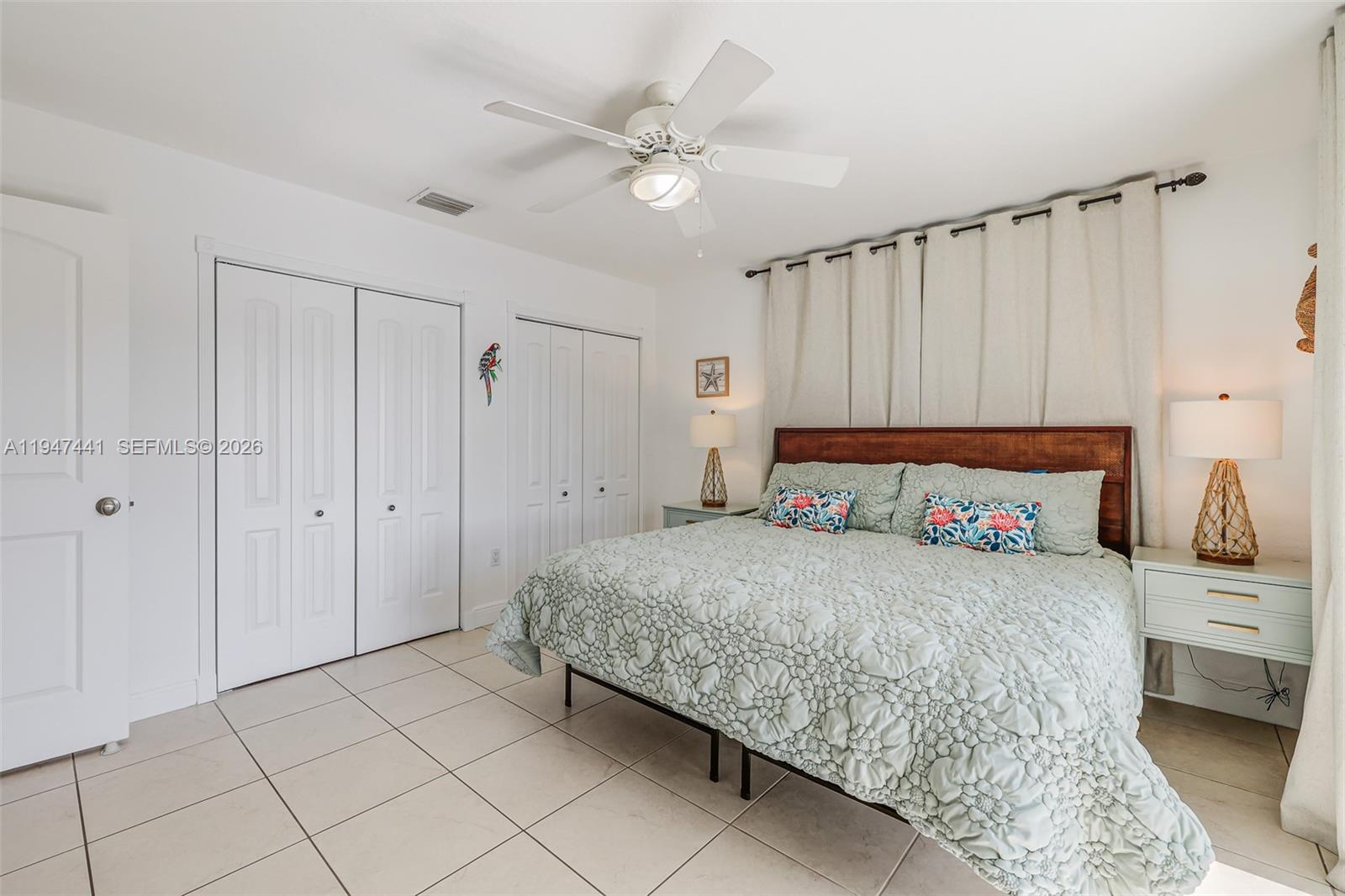 21 Mangrove Lane Key Largo, FL 33037 - Photo 22 of 48 a bedroom with a bed a rug and a ceiling fan