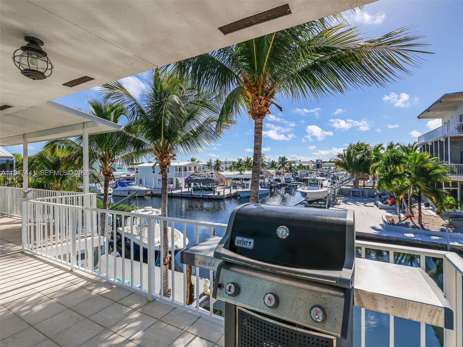 21 Mangrove Lane Key Largo, FL 33037 - Photo 33 of 48 a view of a chairs and table in patio with a lake view
