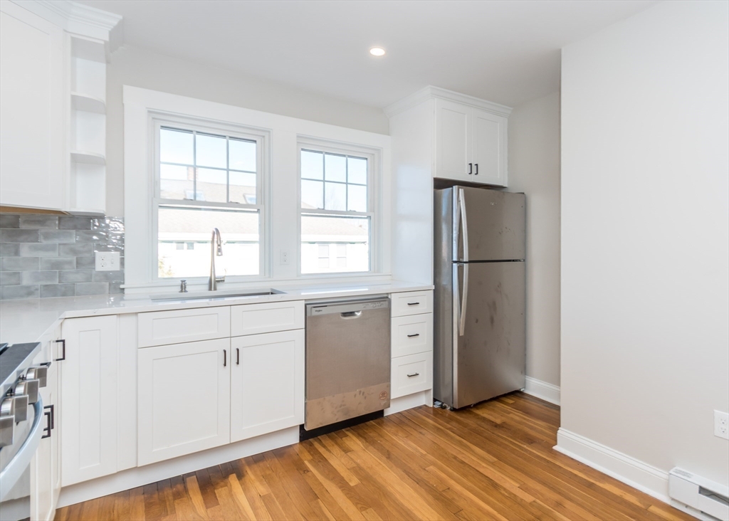 78 Barbara Road, Unit 1 Waltham, MA 02453 - Photo 3 of 15 a kitchen with granite countertop cabinets appliances and a window