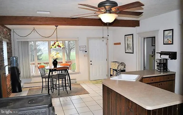 a kitchen with stainless steel appliances kitchen island granite countertop a table chairs in it and wooden floors