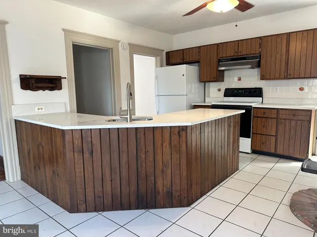 a kitchen with stainless steel appliances a sink a stove a refrigerator and cabinets