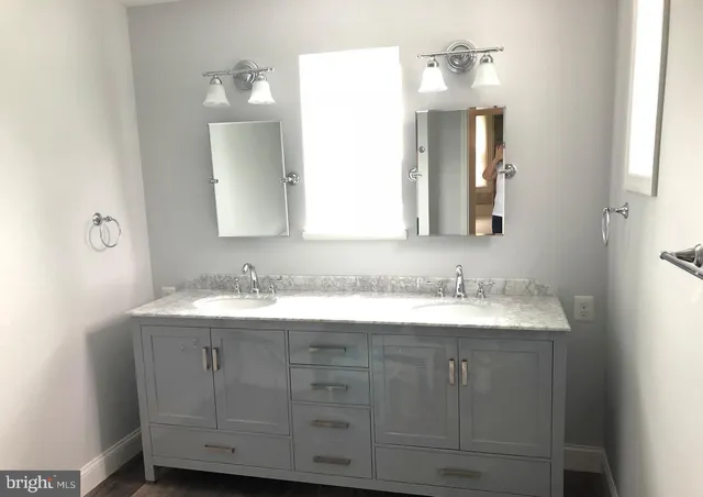 a bathroom with a granite countertop sink double and mirror
