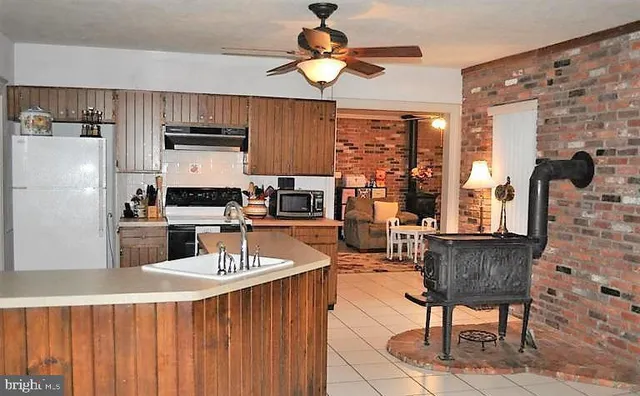 a kitchen with stainless steel appliances a dining table chairs and a refrigerator