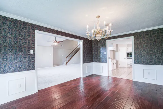 a view of a livingroom with wooden floor and staircase