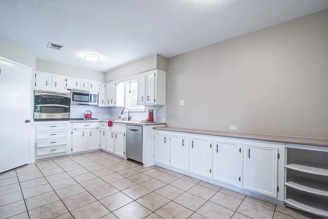 a kitchen with white cabinets and white appliances