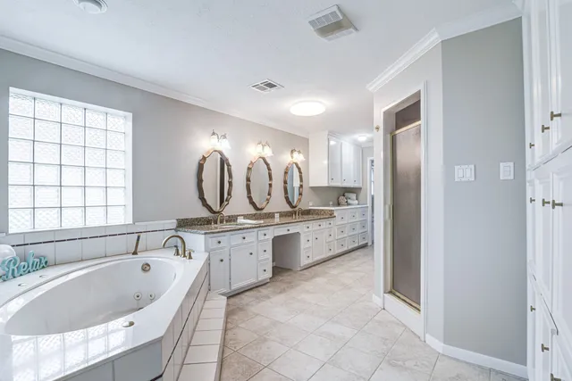 a bathroom with a granite countertop tub sink shower and mirror