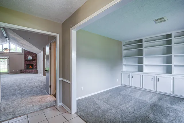 a view of an empty room with cabinet and entryway