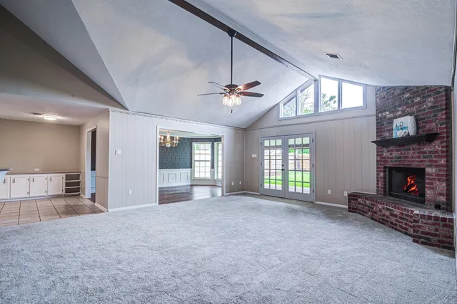 a view of an empty room with a fireplace and a window