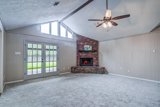a view of an empty room with a fireplace and a chandelier