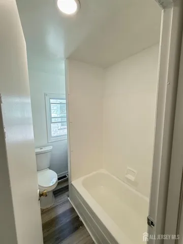a bathroom with a tub and toilet