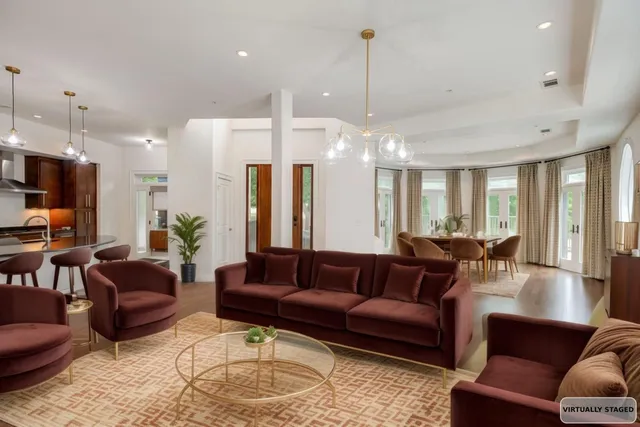 a living room with furniture kitchen and a chandelier
