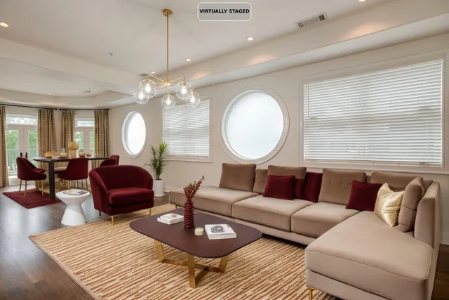 a living room with furniture a large window and a chandelier