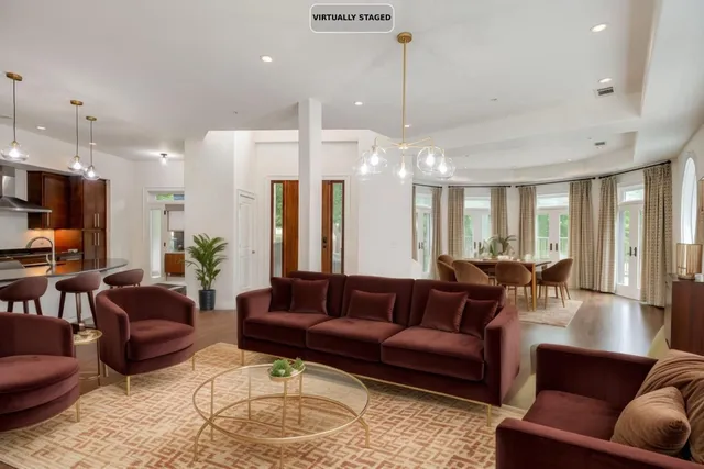 a living room with furniture kitchen and a chandelier