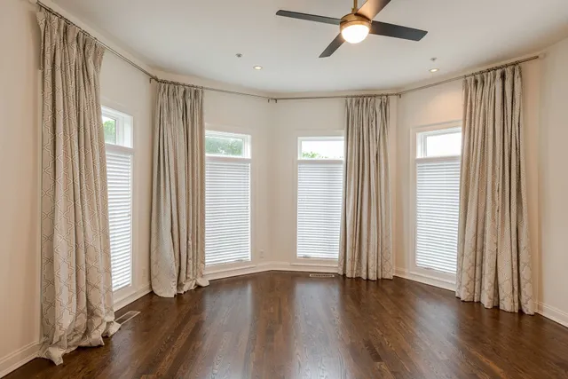 a view of a livingroom with wooden floor and a ceiling fan