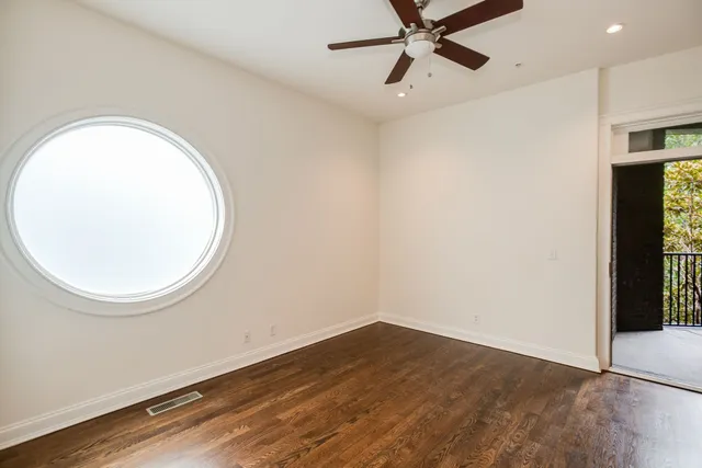 a view of a room with wooden floor and a ceiling fan