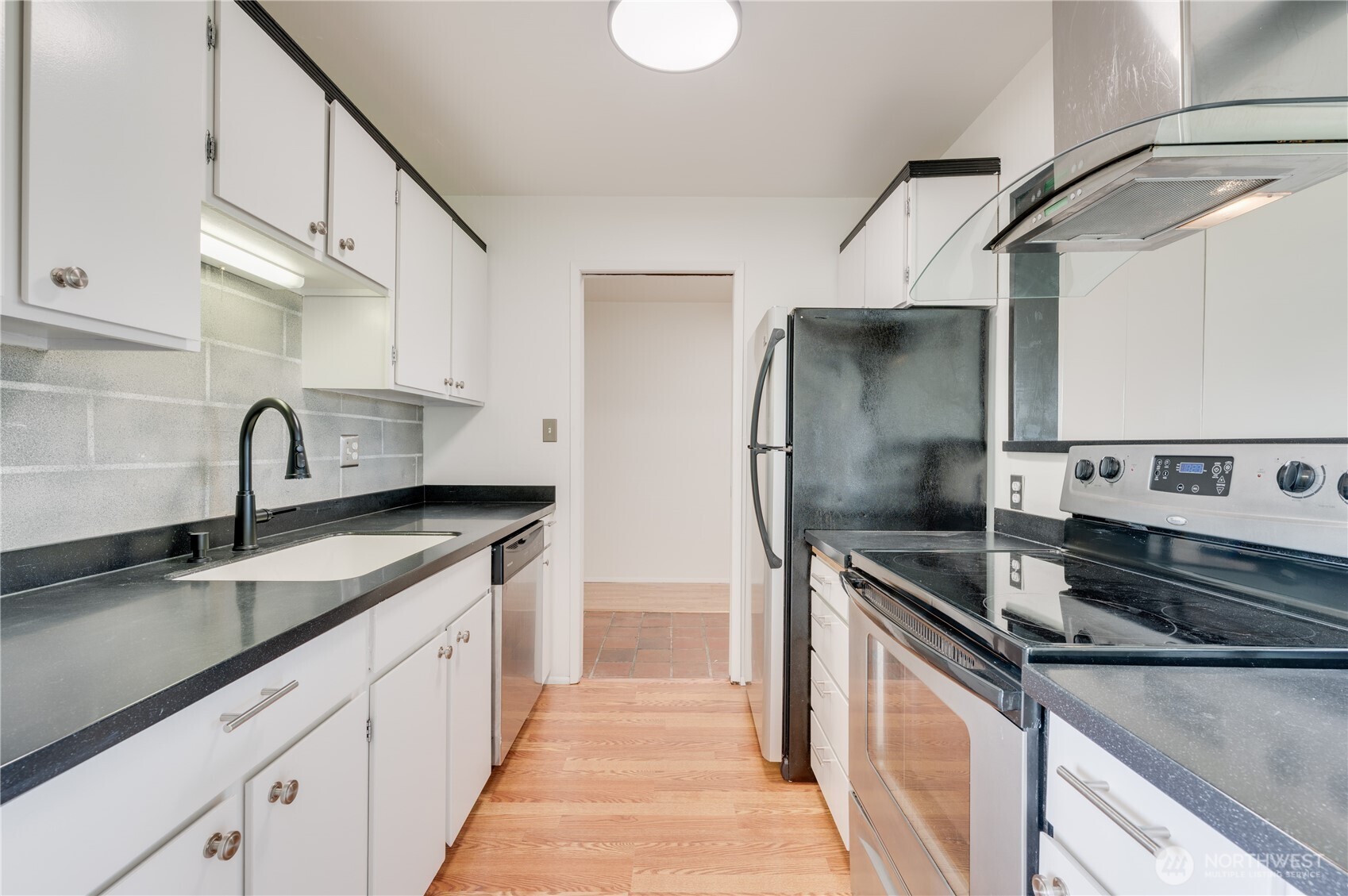 310 South 11th Street, Unit 212 Mount Vernon, WA 98274 - Photo 5 of 18 a kitchen with stainless steel appliances granite countertop a sink and a stove