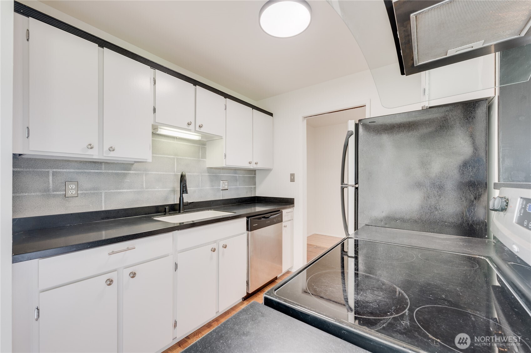 310 South 11th Street, Unit 212 Mount Vernon, WA 98274 - Photo 6 of 18 a kitchen with stainless steel appliances granite countertop a sink a refrigerator and white cabinets