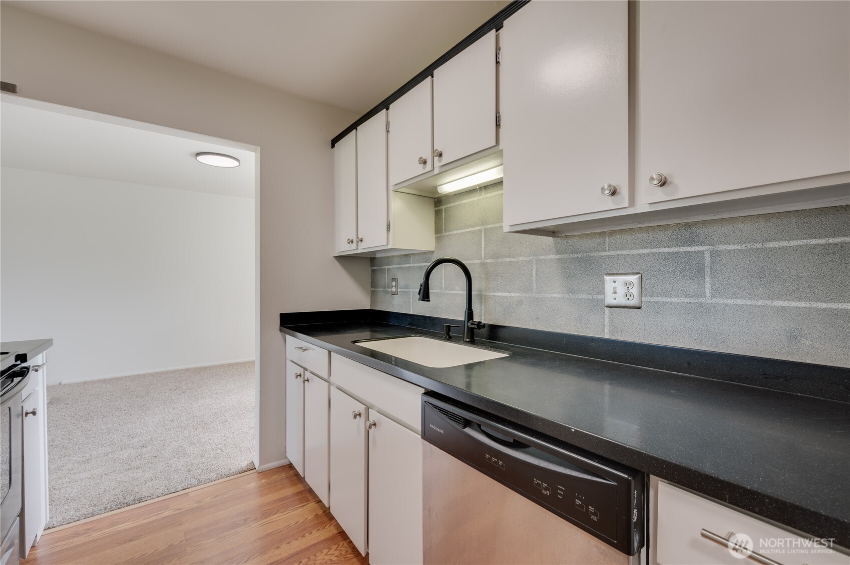 310 South 11th Street, Unit 212 Mount Vernon, WA 98274 - Photo 7 of 18 a kitchen with granite countertop a sink stainless steel appliances and cabinets
