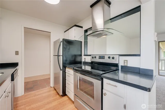 a kitchen with stainless steel appliances granite countertop a sink and a refrigerator
