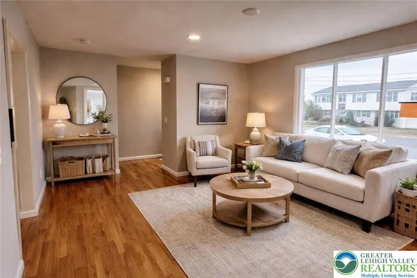 a living room with furniture a table and a large window