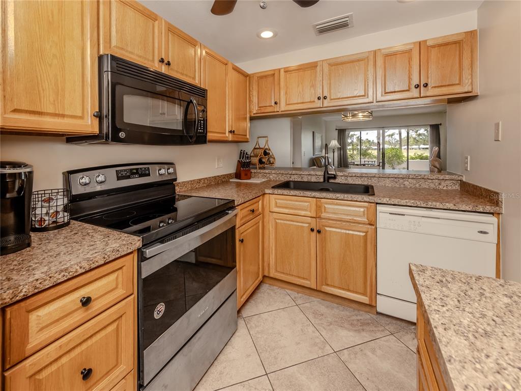 437 Cerromar Lane, Unit 312 Venice, FL 34293 - Photo 14 of 68 a kitchen with a sink stove and microwave