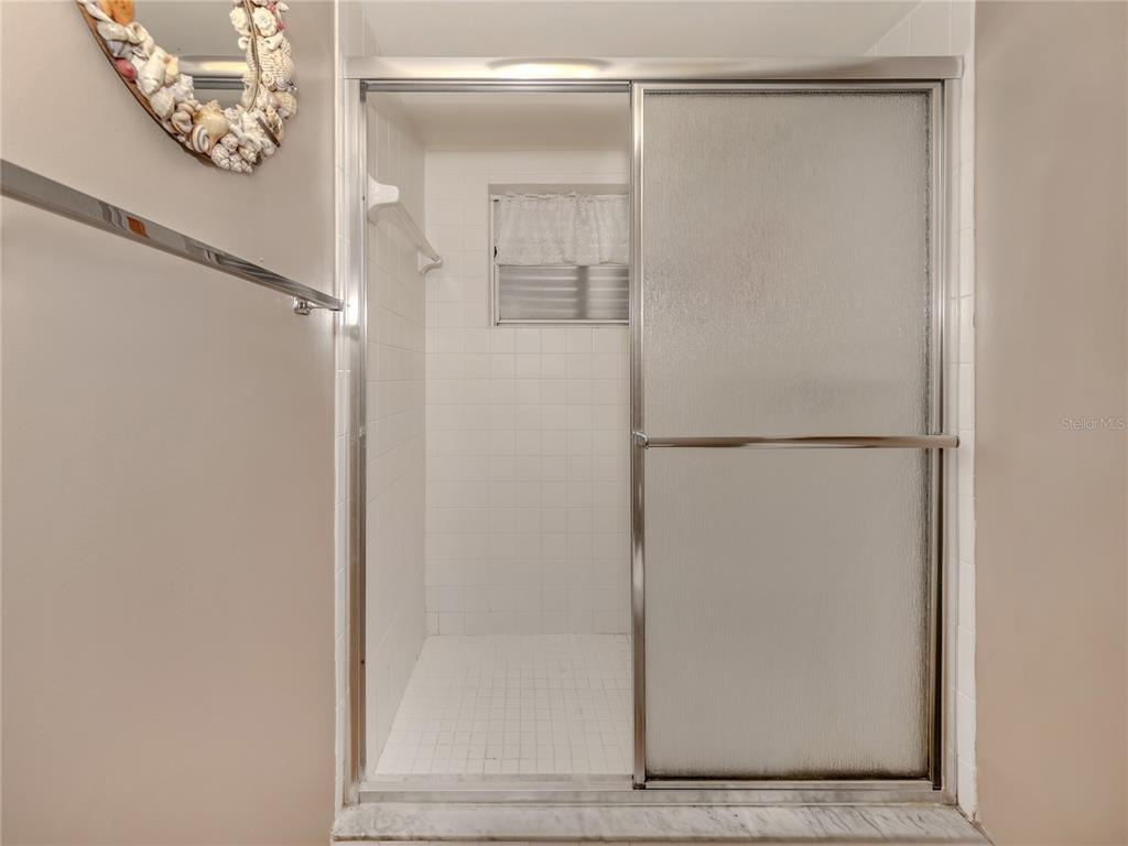 437 Cerromar Lane, Unit 312 Venice, FL 34293 - Photo 19 of 68 a bathroom with a glass shower door