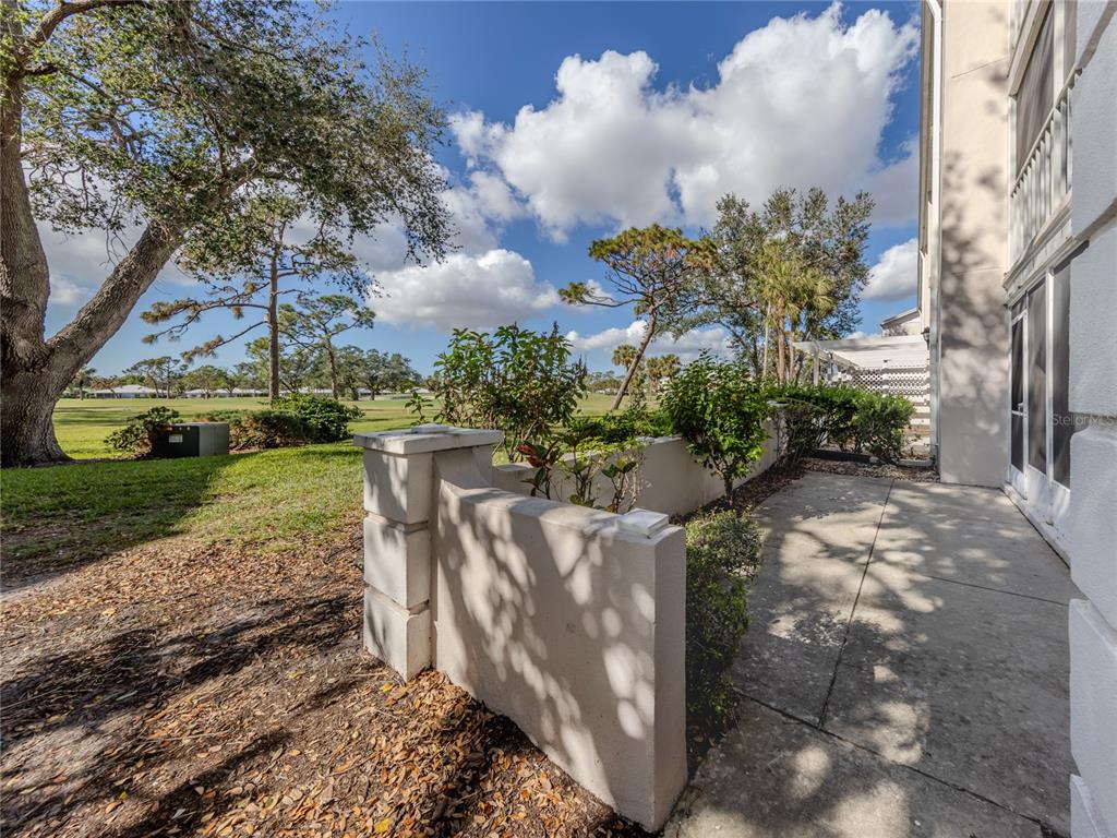 437 Cerromar Lane, Unit 312 Venice, FL 34293 - Photo 27 of 68 a view of a yard with plants and large trees