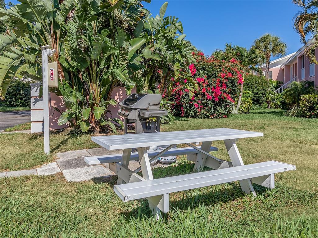 437 Cerromar Lane, Unit 312 Venice, FL 34293 - Photo 32 of 68 a view of a wooden bench and chair in the yard