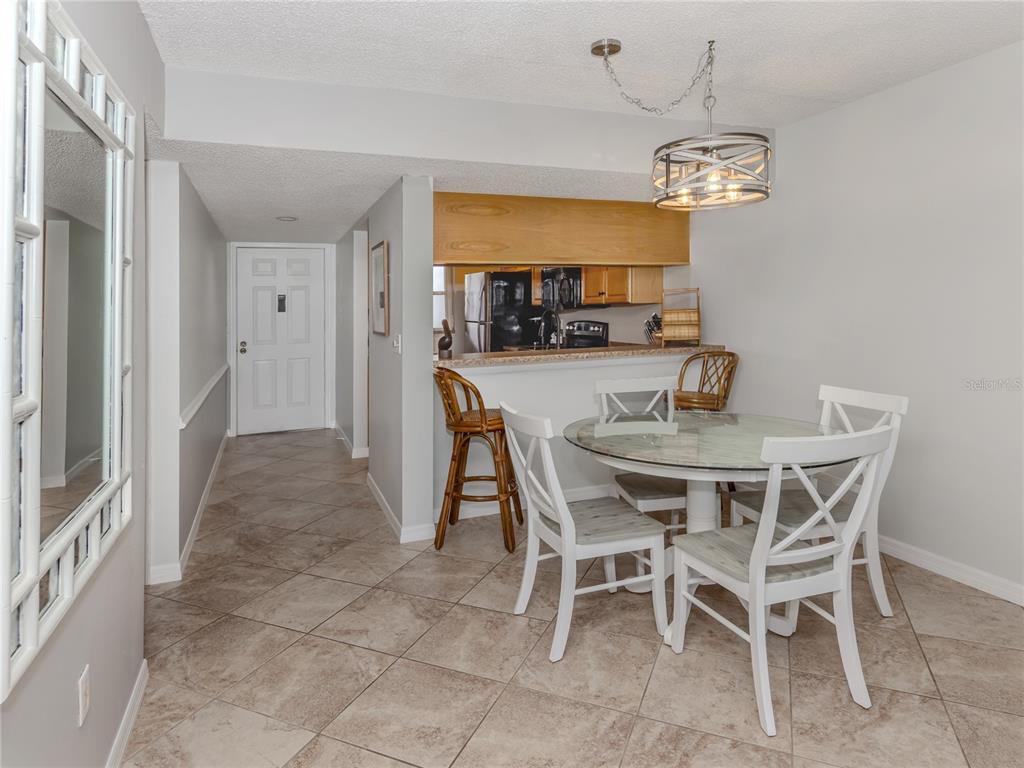 437 Cerromar Lane, Unit 312 Venice, FL 34293 - Photo 10 of 68 a view of a dining room with furniture and chandelier