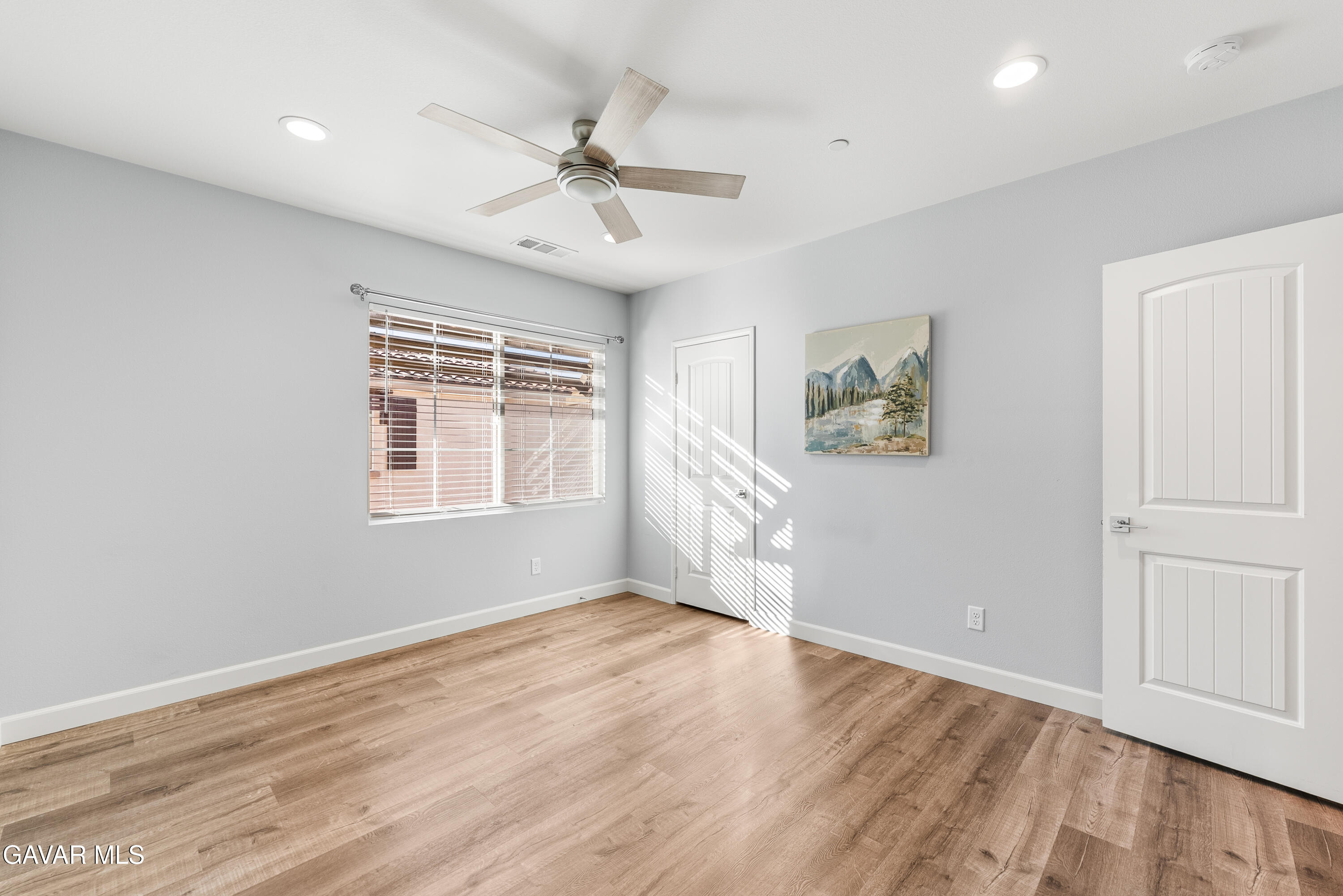 2108 Cork Oak Street Palmdale, CA 93551 - Photo 11 of 55 an empty room with wooden floor fan and windows