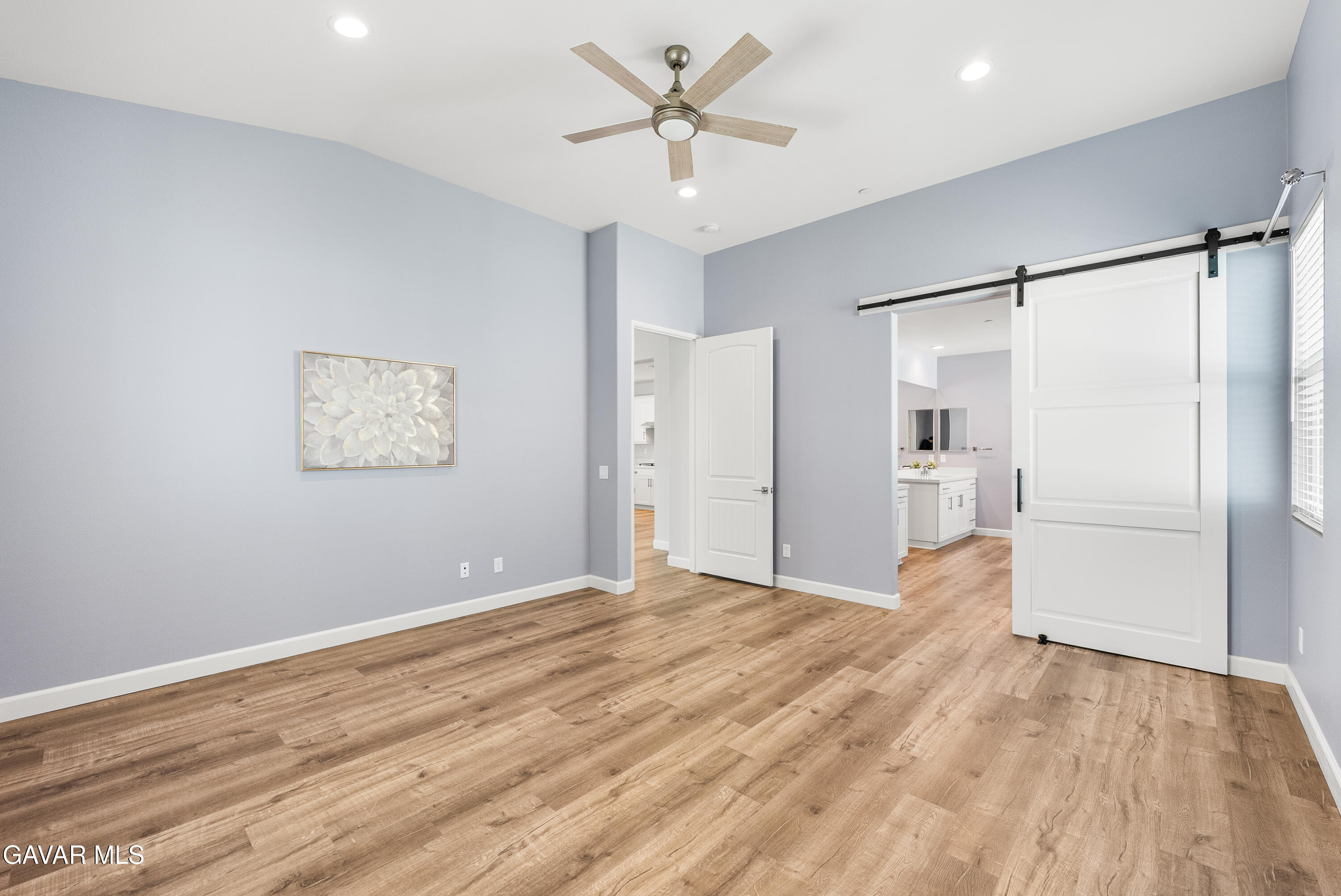 2108 Cork Oak Street Palmdale, CA 93551 - Photo 44 of 55 a view of a big room with wooden floor and a ceiling fan in a living room