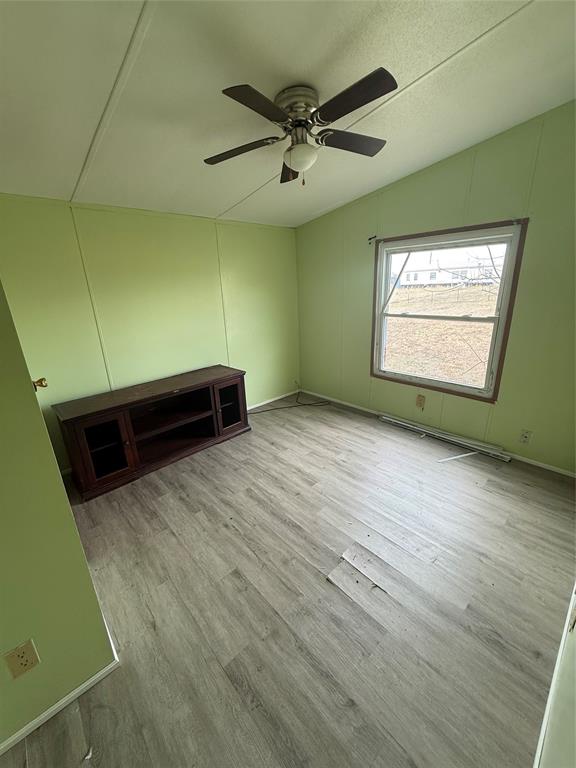 118 Happy Trl Court Rhome, TX 76078 - Photo 7 of 9 a view of a room with a ceiling fan and wooden floor