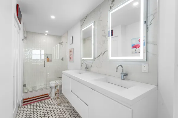 a bathroom with a sink a toilet a shower and a mirror