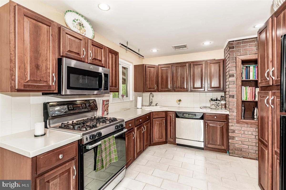 396 Riverside Drive Princeton, NJ 08540 - Photo 8 of 39 a kitchen with stainless steel appliances granite countertop a stove top oven a sink dishwasher a dining table and chairs with wooden floor