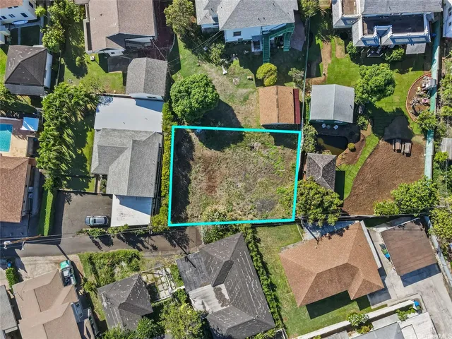 an aerial view of a house with garden space and street view