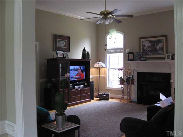 1001 Fieldgrass Place Raleigh, NC 27603 - Photo 11 of 20 Large Room, Hardwood under carpet, gas logs in fireplace, chair railing and crown molding Den/Family/Great Room